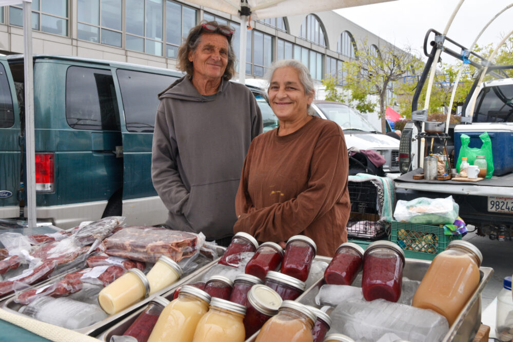 Norman and Aimee Gunsell pose at Mountain Ranch's stand at the Ferry Plaza Farmers Market in San Francisco.
