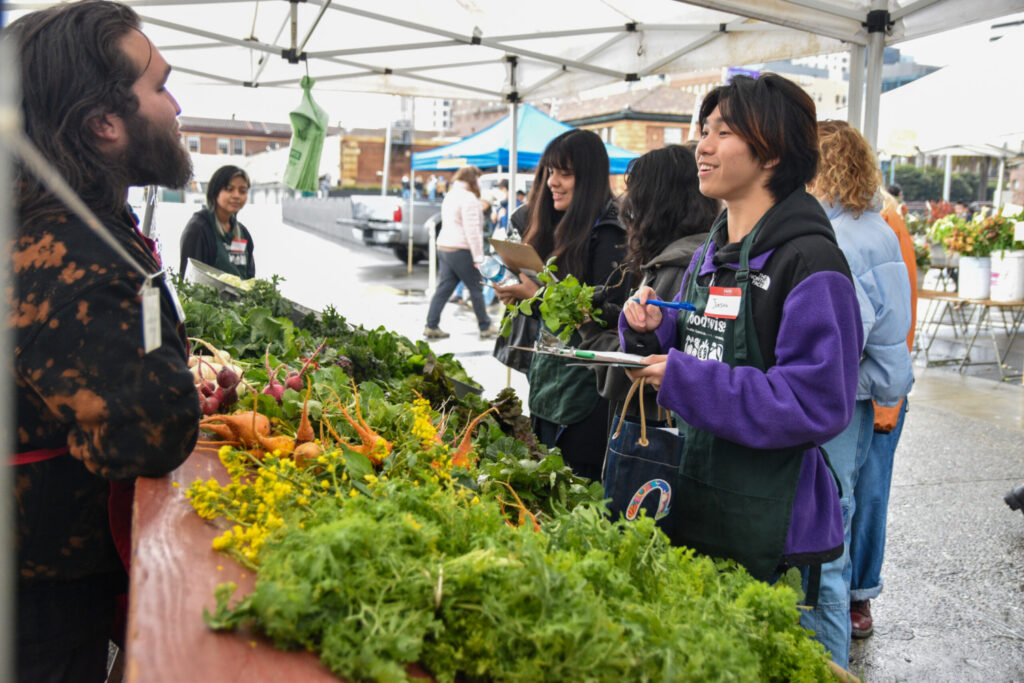 Foodwise Teens talk with a farmers market seller.