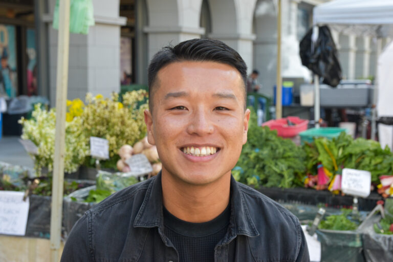 Tommy Phung headshot, with the Ferry Plaza Farmers Market in the background
