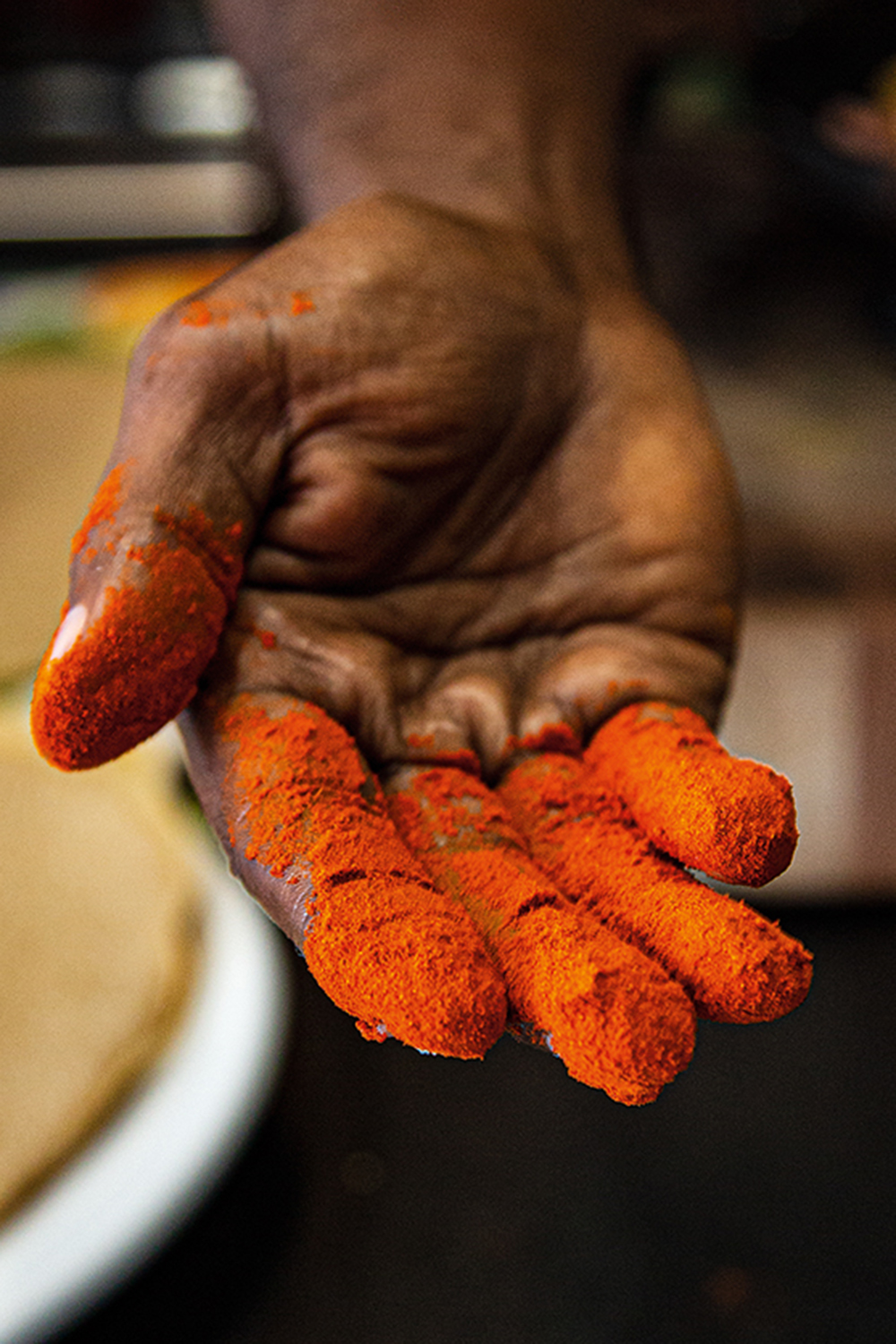 A hand covered in bright red powder.