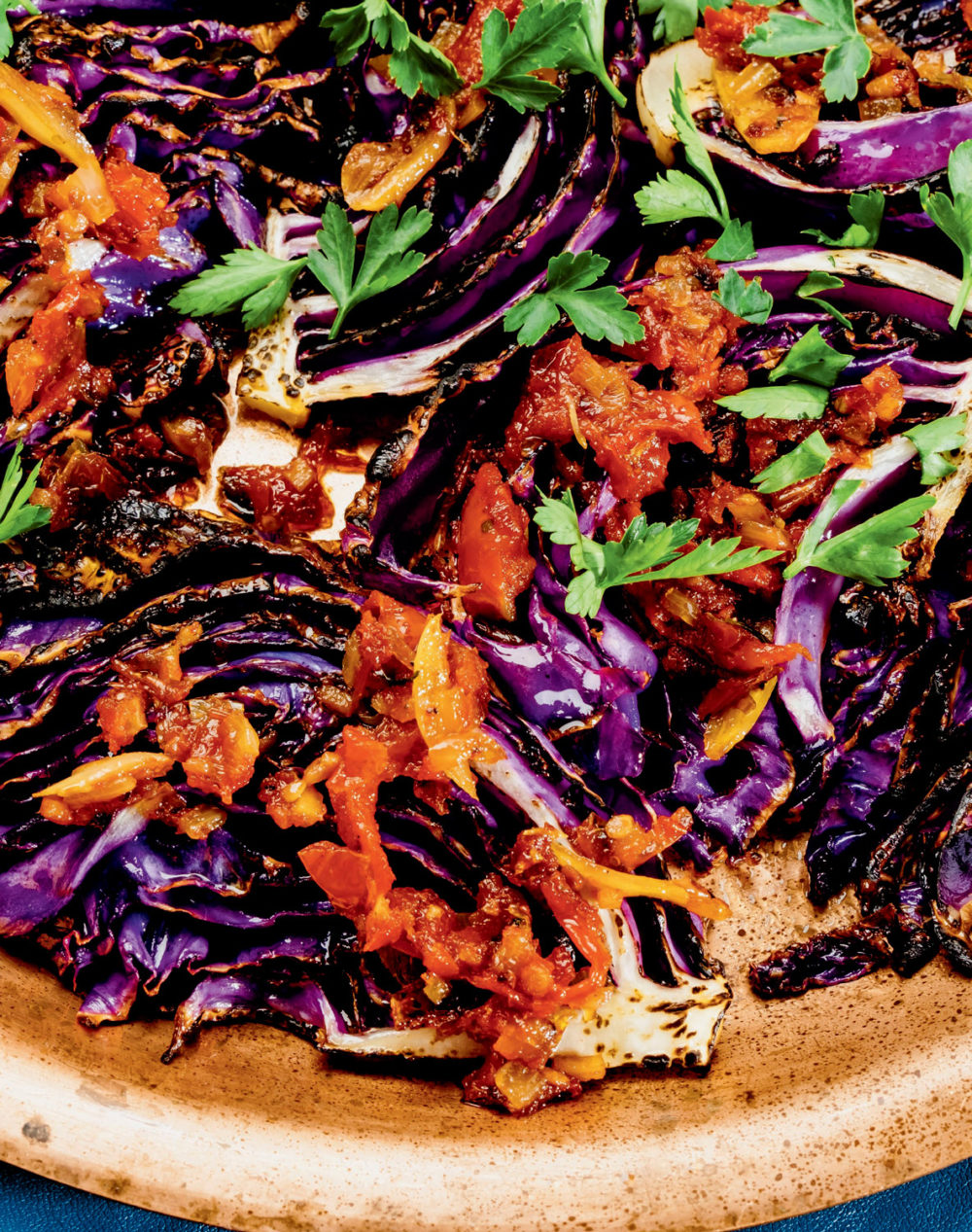 Charred purple cabbage with a red sauce drizzled on top.