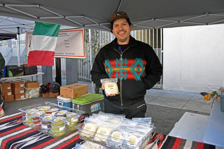 Emmanual Galvan holds tortillas at Bolita's stand at the Mission Community Market in San Francisco.