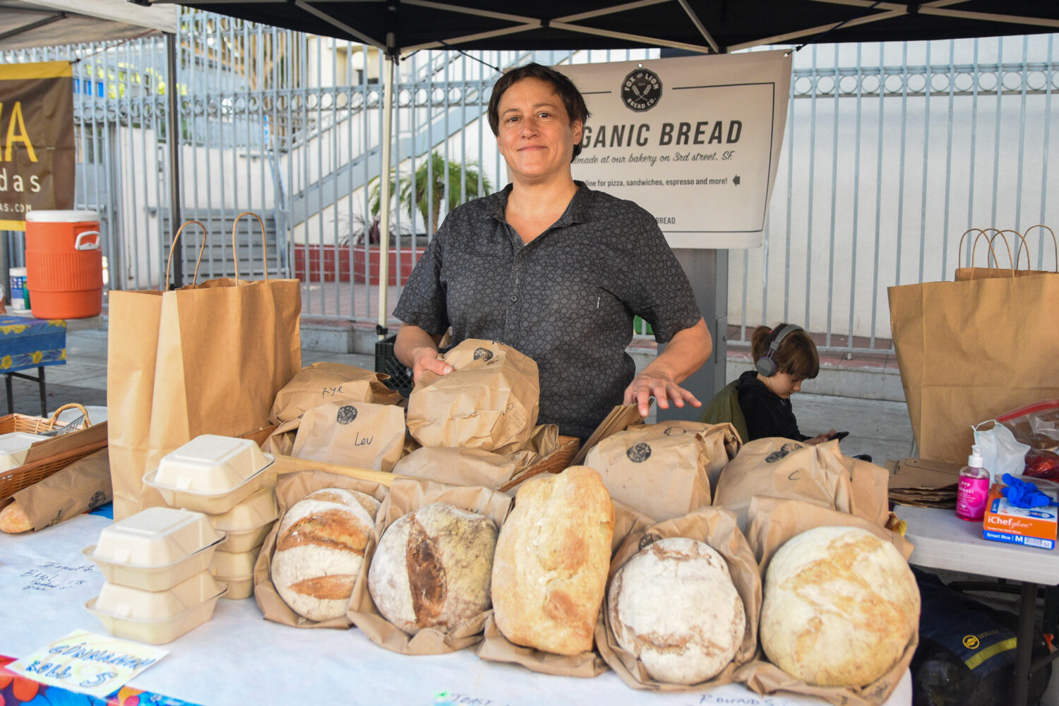 Baker Xan poses with bread at Fox and Lion Bread Co.'s stand at the Mission Community Market in San Francisco.