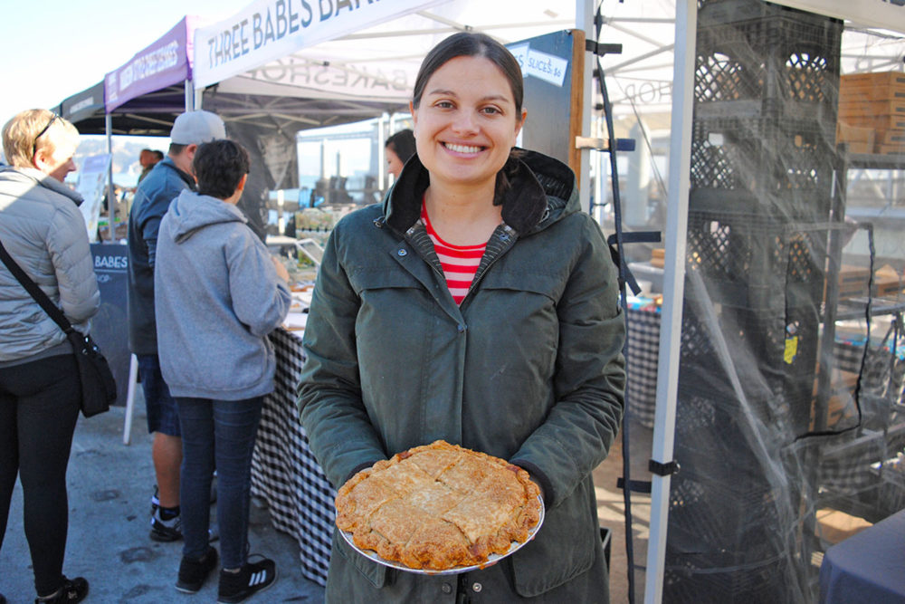Lenore holds a pie in front of Three Babes Bakeshop at the Ferry Plaza Farmers Market.