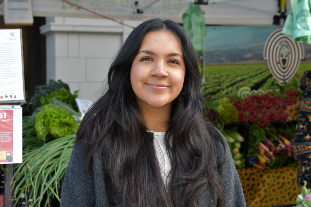 Photo of Nesley Rojo, in front of a stand at Foodwise's Ferry Plaza Farmers Market