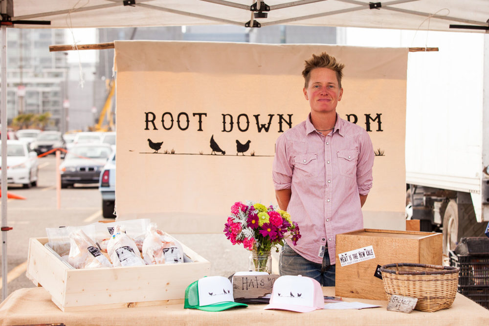 Dede poses at Root Down Farm's stand at a Foodwise Farmers Market