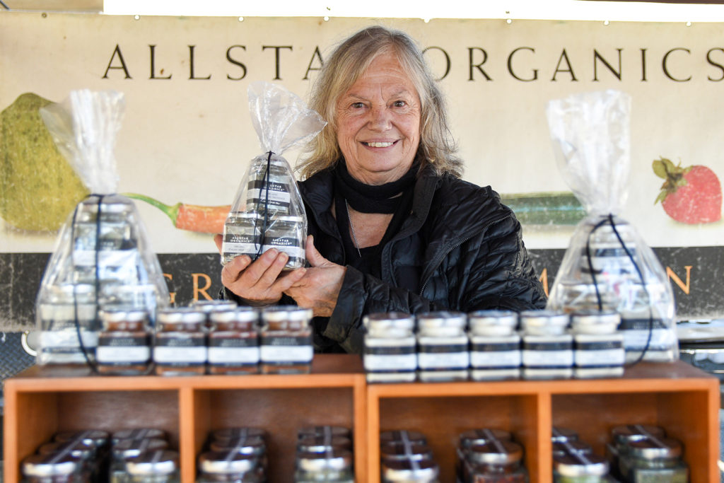 Janet Brown of Allstar Organics holding herb products at Ferry Plaza Farmers Market stand