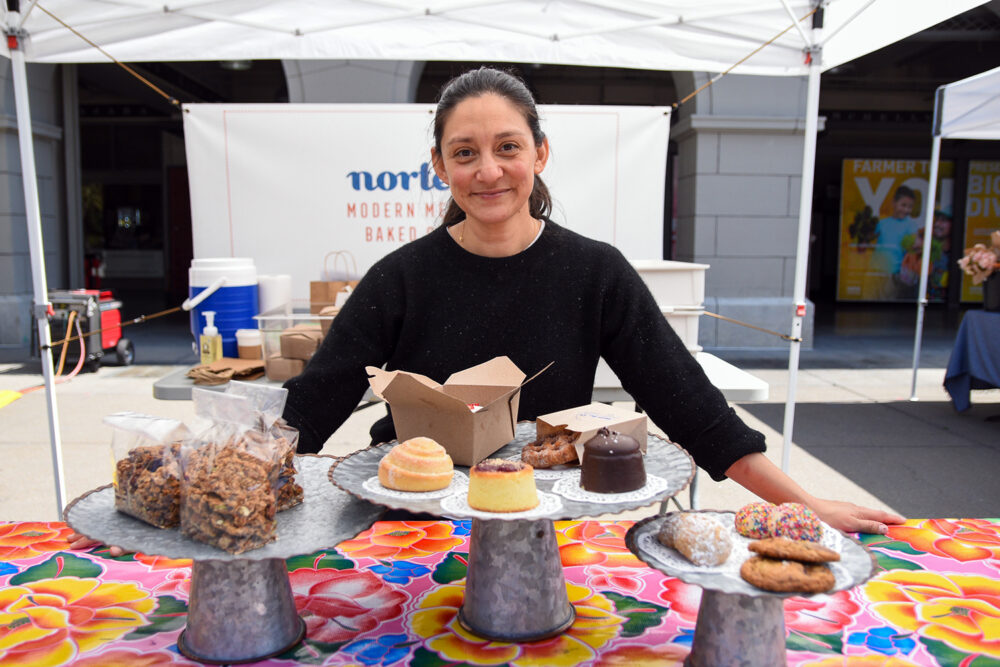 Raquel Goldman poses with pan dulce at Norte54's stand at Foodwise's farmers market in San Francisco.