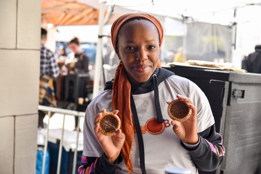 Zakiyyah Shaheed, holds two mini pies at Pop-Ups on the Plaza: Black Holiday Market 2023