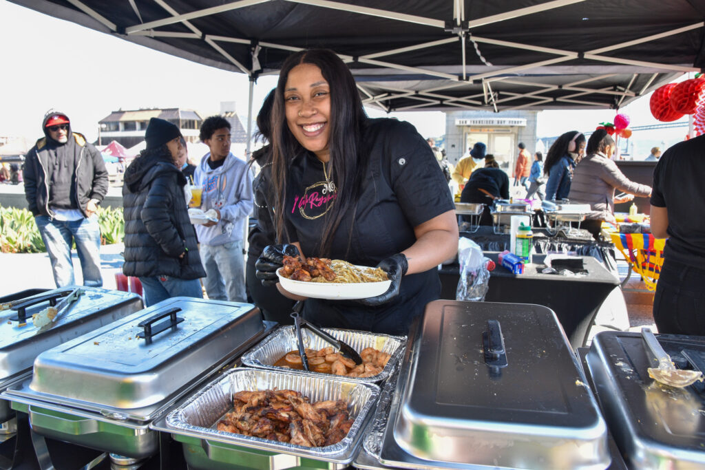 Mo'Raysha Pouoa holds a dish of food at Foodwise's Pop-Ups on the Plaza event at the Ferry Plaza Farmers Market in San Francisco.