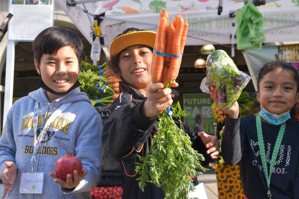 Foodwise Kids holding fruits and vegetables at the farmers market