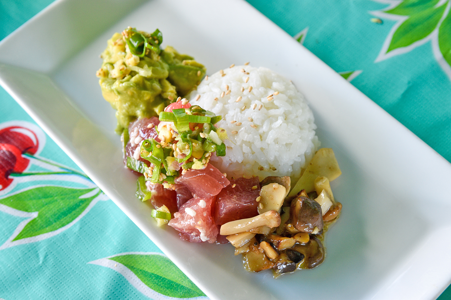 A dish with avocado, tuna poke, sauted mushrooms, and a mound of white rice.