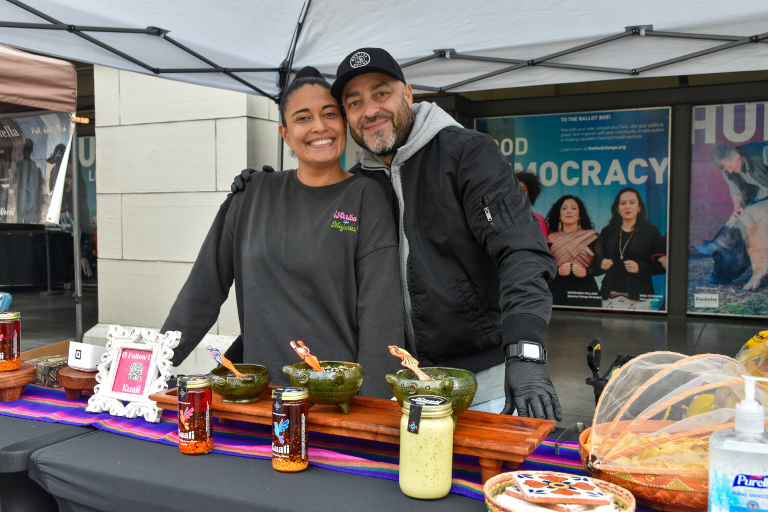 Janeen and Rodrigo posing at Kuali's stand with their salsa macha at the Ferry Plaza Farmers Market.