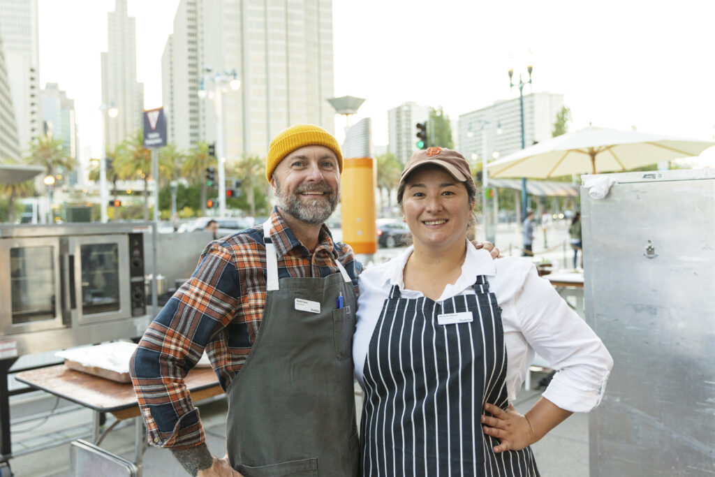 Daniel Capra and Michelle Minori at Foodwise Sunday Supper, with the city skyline in the background
