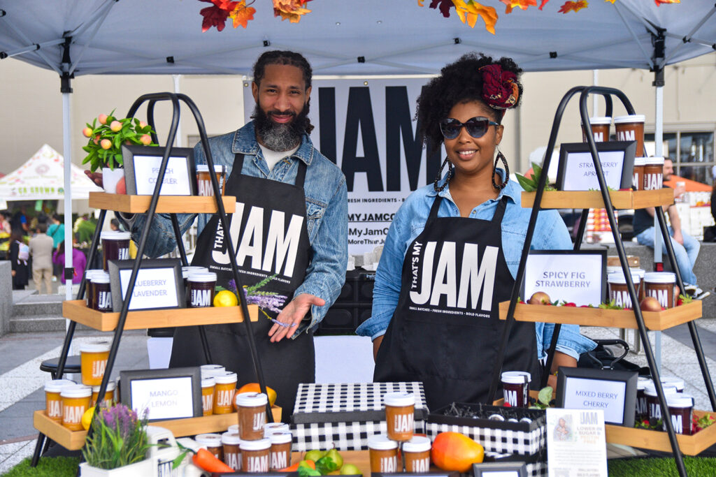 Two people pose at That's My Jam's stand at Foodwise's Pop-Ups on the Plaza event at the Ferry Plaza Farmers Market in San Francisco