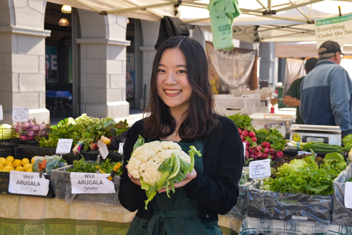 Yuki Tatsumi poses with a cauliflower at Foodwise's Ferry Plaza Farmers Market in San Francisco.