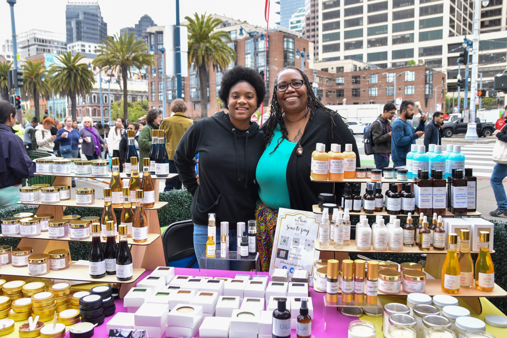 Vickie Brown poses at Ice Body Shop's stand at In The Black's pop-up craft market at Foodwise's Ferry Plaza Farmers Market in San Francisco.