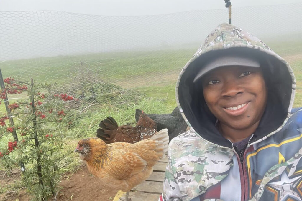 Priscilla Lucero poses on Lucero Organic Farms with chickens.