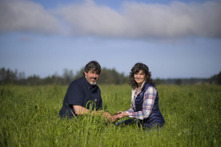Two people sit in a field