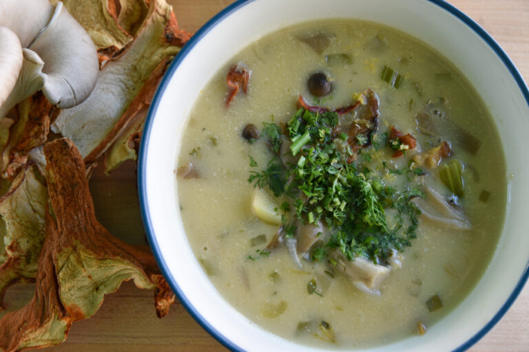 a bowl of chowder, with mushrooms on the side