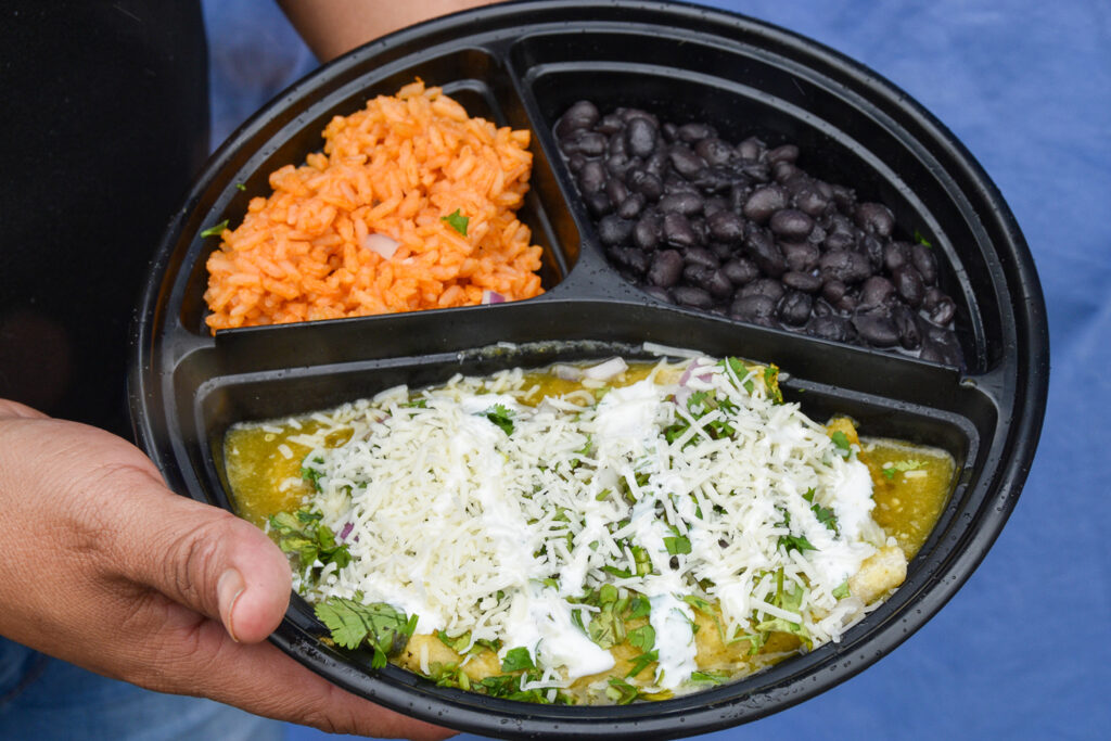 a plate of vegetarian enchiladas with rice and beans