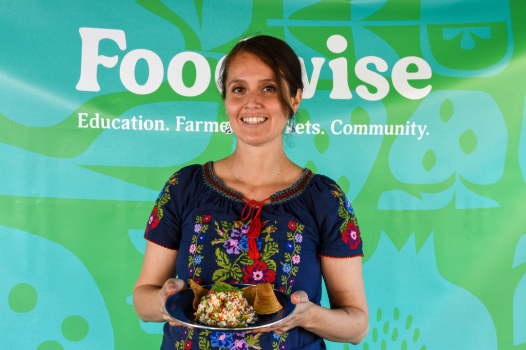 Maria Gonzalez holds a plate of vegan ceviche with tortilla chips.