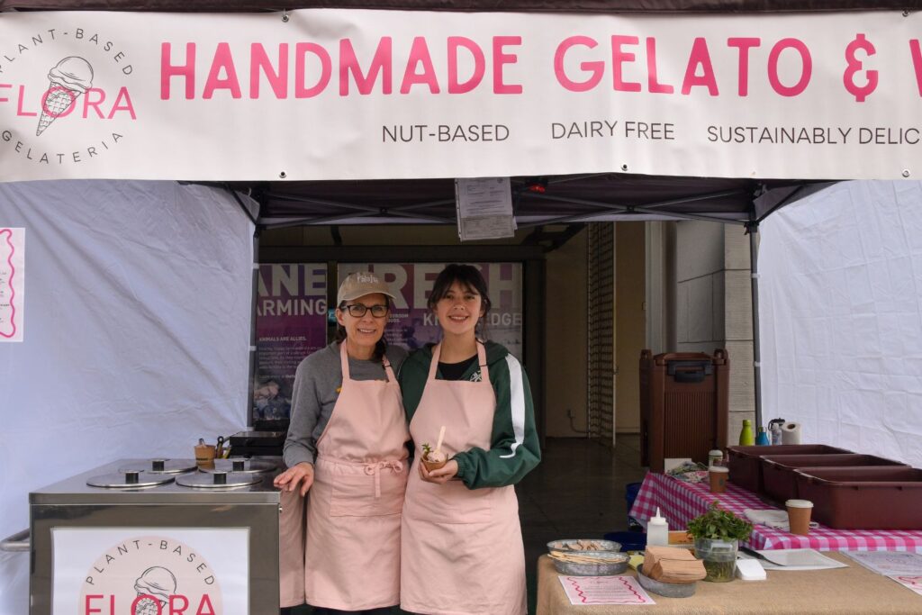 Christine and Audrey stand inside a pink under a banner labeled 'Handmade Gelato'