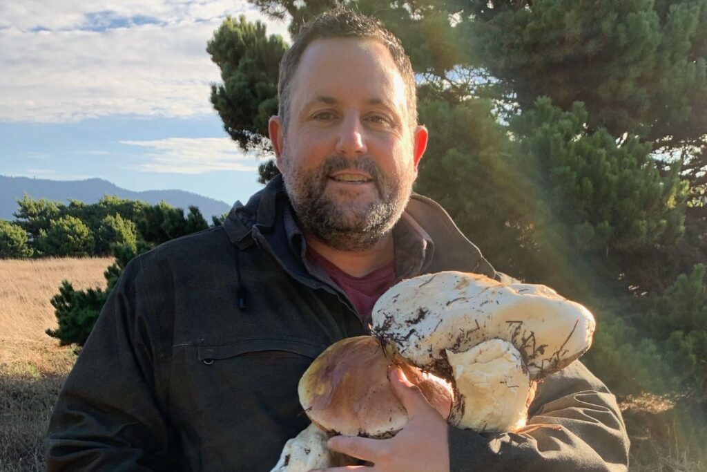 Ian Garrone holds a large mushroom.